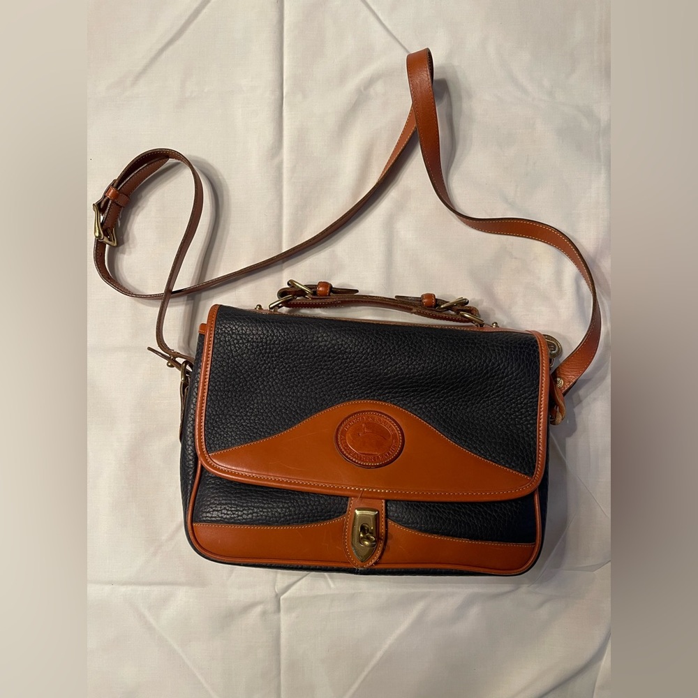 Dooney & Bourke shoulder bag with handle in navy with tan trim.